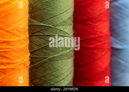 Multi-colored spools of thread close-up. Needle with thread. Seamstress or tailor's tools Stock Photo