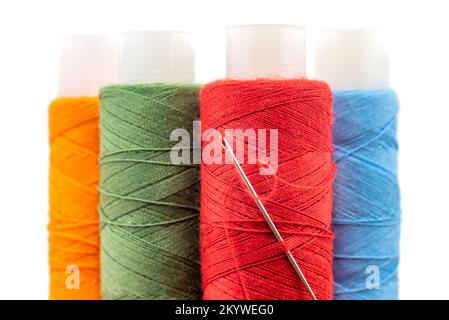 Multi-colored spools of thread close-up. Needle with thread. Seamstress or tailor's tools Stock Photo
