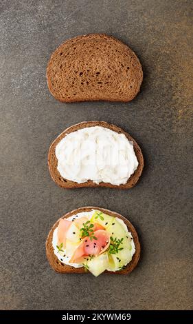 Three slices of rye bread showing three stages of making sandwich with ham and cucumber Stock Photo