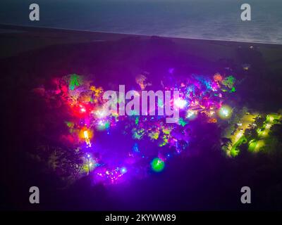 Abbotsbury, Dorset, UK.  2nd December 2022.  View from the air at dusk of the Abbotsbury Subtropical Gardens at Abbotsbury in Dorset which are illuminated with colourful lights during December for their Illuminate event.  Picture Credit: Graham Hunt/Alamy Live News Stock Photo