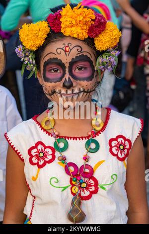 A young girl in costume as La Catrina with face paint for a Day of