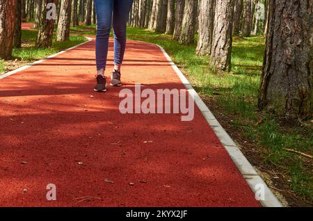 Red running rout with a girl running on it Stock Photo