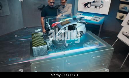 Two engineers Developers standing in design studio near futuristic holographic table and make a test in a 3d car crash test simulator, which simulates a road accident check the safety Stock Photo
