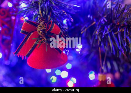 Red bell hanging on the Christmas tree at home Stock Photo