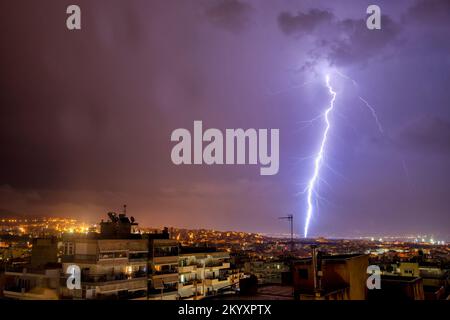 night city view under thunderstorm with strike of lightning. Powerful thunderbolt during thunderstorm in the city. Cloud to ground electric lightning Stock Photo