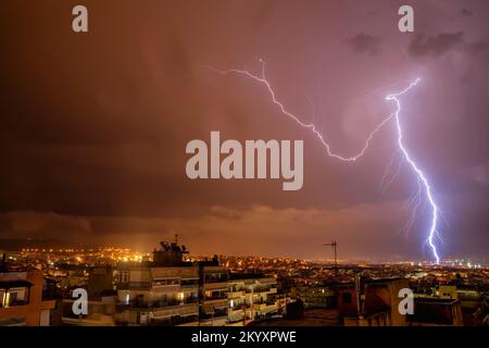 night city view under thunderstorm with strike of lightning. Powerful thunderbolt during thunderstorm in the city. Cloud to ground electric lightning Stock Photo