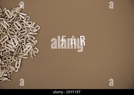 FAR in wooden English words language capital letters spilling from a ...