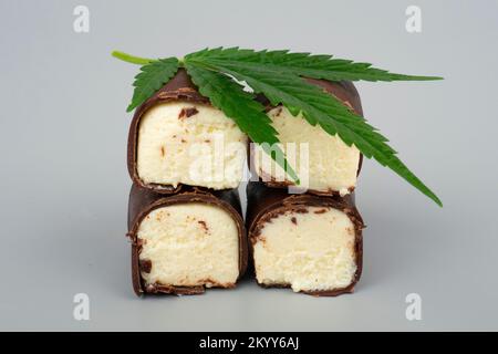 green marijuana leaf and chocolate sweet covered milk cheese with cannabis oil. Stock Photo