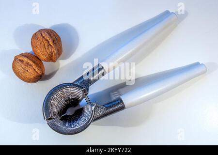 Two Walnuts and a Nutcracker on a white background Stock Photo