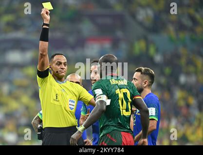 Lusail. 2nd Dec, 2022. Referee Ismail Elfath (L) shows a yellow card to Vincent Aboubakar (2nd R) of Cameroon during the Group G match between Cameroon and Brazil at the 2022 FIFA World Cup at Lusail Stadium in Lusail, Qatar, Dec. 2, 2022 Credit: Xiao Yijiu/Xinhua/Alamy Live News Stock Photo