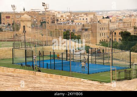 Valletta, Malta - November 12, 2022: 16th century  fortification with the paddle tennis court and a football pitch,  and view of Floriana town, from t Stock Photo