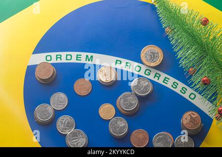 Translation 'order progress'Brazilian flag with Brazilian real coins and a christmas tree fell next to,year-end concept. Stock Photo