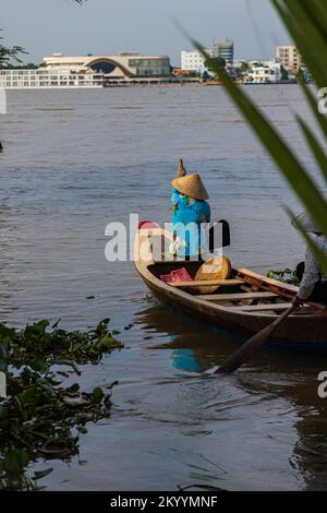 Ho Chi Minh City, Vietnam- November 9, 2022: Two Vietnamese woman, with traditional conical hat, in a paddle boat or canoe on the Mekong river. Boat t Stock Photo