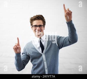 Touching technology. A handsome young nerdy guy pointing his fingers as if touching something. Stock Photo