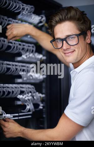 Ready to get you back online. A computer technician connecting cables. Stock Photo