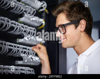 Ready to get you back online. A computer technician connecting cables. Stock Photo