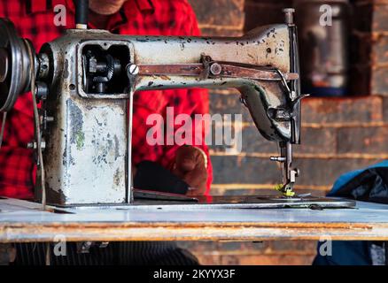 Midsection of a man sewing on an old sewing machine in Kathmandu, Nepal Stock Photo