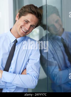 Positive young businessman. A handsome young businessman crossing his arms and smiling at you. Stock Photo