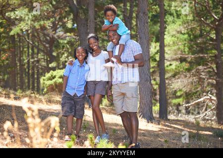 Hiking is their favorite weekend activity. Portrait of an african american family enjoying a day out in the forest. Stock Photo