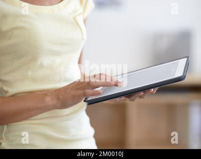 Touchscreen technology. A cropped image of a woman working on a digital tablet - closeup. Stock Photo