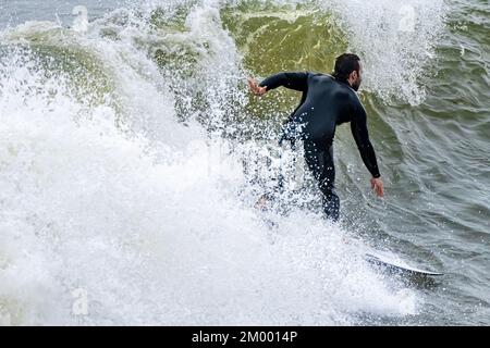 Surfer taking off on a late autumn swell near the Jacksonville Beach Pier in Jacksonville Beach, Florida. (USA) Stock Photo