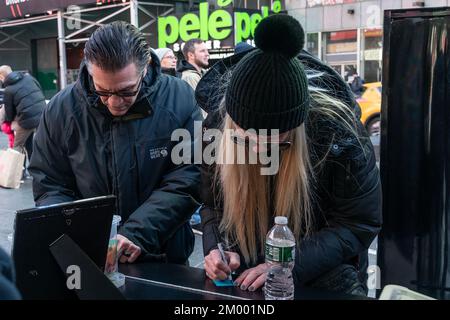 New York, New York, USA. 2nd Dec, 2022. People write down notes on confetti before they are pinned on a Wishing Wall station on Times Square ahead of New Year's Eve. New Yorkers and tourists alike take an opportunity to be a part of New Year's Eve in Times Square by writing their wishes for the upcoming year on pieces of confetti that are pinned to the Wishing Wall and will be released at midnight on New Year's Eve. (Credit Image: © Lev Radin/Pacific Press via ZUMA Press Wire) Stock Photo