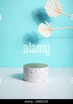 Podium for beauty product promotion, spring cotton twig on light blue. Empty showcase for cosmetics presentation. Top view. Stock Photo