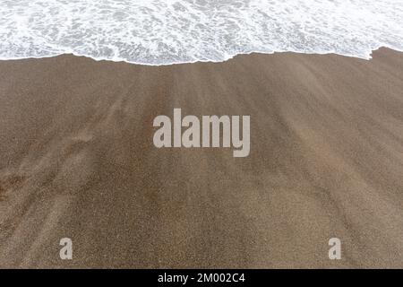Ocean beach aerial top down view with blue water, waves with foam and spray and fine sand, beautiful summer vacation holidays Stock Photo