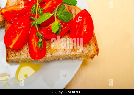 Italian tomato bruschetta with thyme and mint leaves Stock Photo