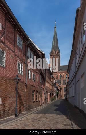 Old town alley with historic houses, Nikolai Church in the back, Lüneburg, Lower Saxony, Germany, Europe Stock Photo