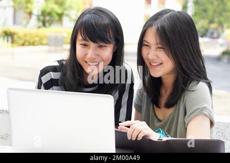 We love university. Two young students sitting outside together. Stock Photo