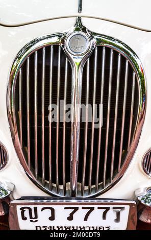 A white Jaguar is parked at the curb in Old Town, Bangkok. Stock Photo