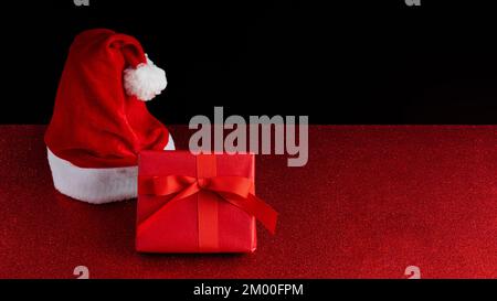 Christmas background with copy space in red and black colors over a glitter backdrop Stock Photo