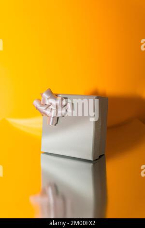 Still life of wrapped present box in gray with a curly ribbon Stock Photo