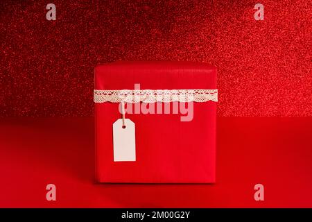 gift box  with a beige ribbon on a red background close-up. Copy space and mock up Stock Photo