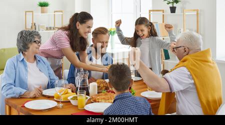 Happy mom, dad, grandma, grandpa and children having fun during family meal at home Stock Photo