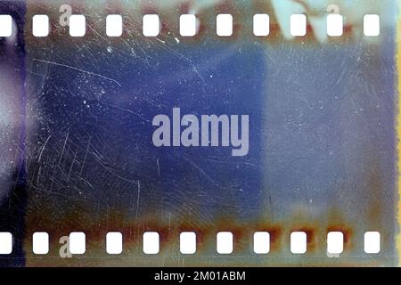 Dusty and grungy 35mm film texture or surface. Perforated scratched camera film isolated on white background. Stock Photo