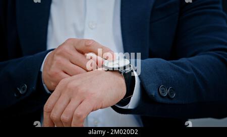 Cropped view closeup male hand with wristwatch clock Asian middle-aged businessman manager man male boss company CEO entrepreneur employer check time Stock Photo
