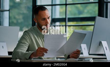 Pensive leader company CEO thinking African businessman boss auditor checking corporate documents financial audit male worker busy with paperwork Stock Photo