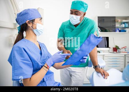 Two doctors discuss in the clinic, African and Asian dentists during work Stock Photo