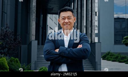 Male portrait in city outdoors 40s middle-aged smiling positive adult Asian Korean man entrepreneur manager company CEO realtor businessman boss Stock Photo