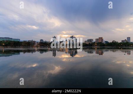 Waterfront apartments with lights and dramatic sky after sunset Stock Photo