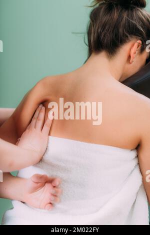 Chair massage therapist massaging woman's back Stock Photo