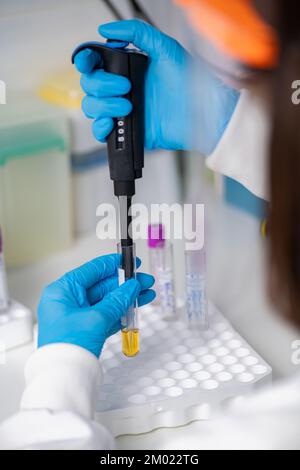 Lab technician pipetting a sample Stock Photo