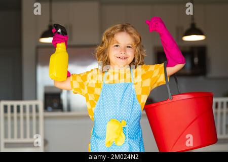 Child use duster and gloves for cleaning. Funny child mopping