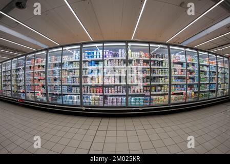 Cuneo, Italy - November 30, 2022: large refrigerator showcases display dairy products, mozzarella and yogurt for sale in Italian supermarket Stock Photo