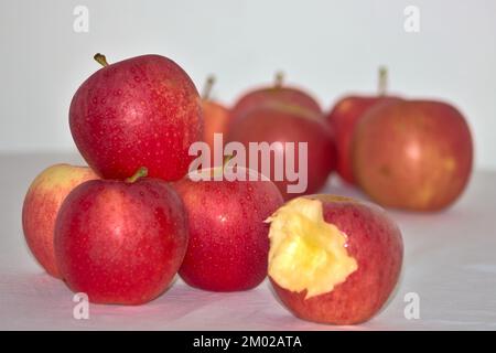 grouping of red apples, one of them bitten, on white background Stock Photo