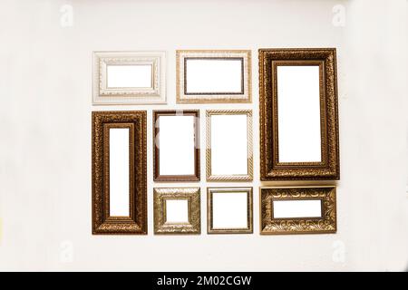 Different size framed photos hanging on the grey wall. Stock Photo