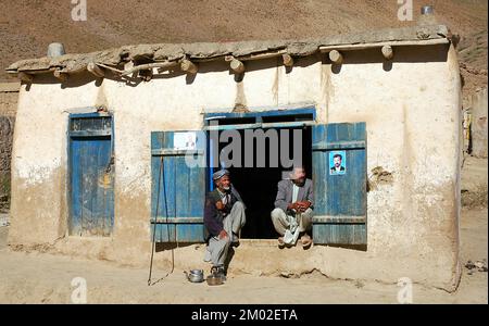 Syadara (Siyah Darah), Bamyan (Bamiyan) Province / Afghanistan: Two Afghan men sit in a doorway in the small town of Syadara in Central Afghanistan. Stock Photo