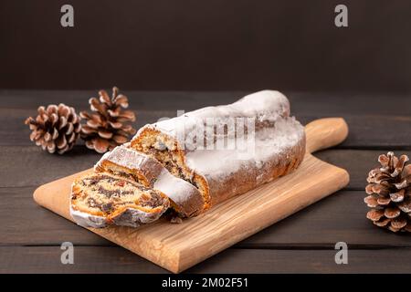 Traditional Christmas cake Stollen on dark wooden background with copy space Stock Photo